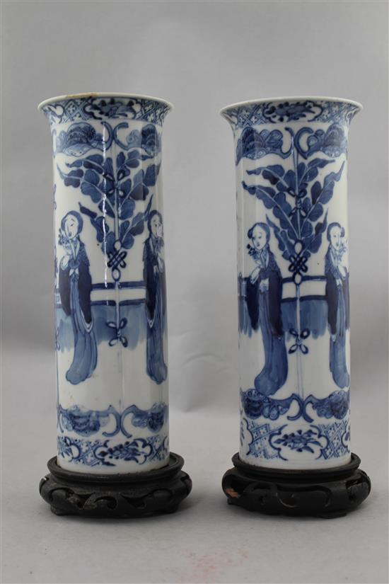 A pair of Chinese blue and white Long Eliza cylindrical vases, late 19th century, 26cm., ebonised wood stands